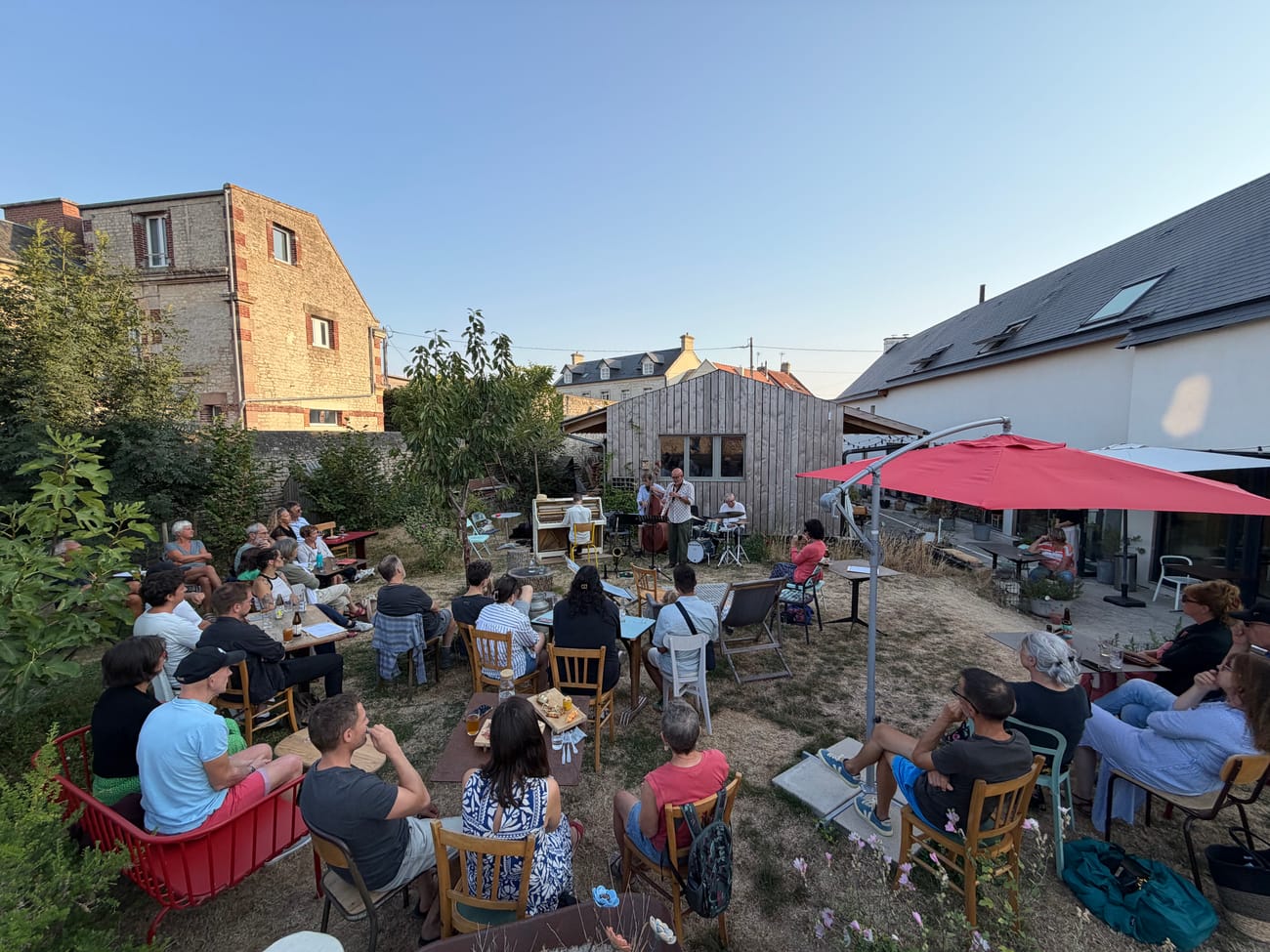 Evening in the garden of Les Briques, string lights and red parasol