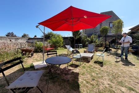The garden set up for an evening, red parasol and microphone