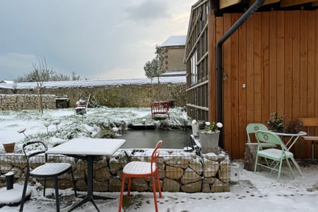 La terrasse sous la neige devant le bardage bois